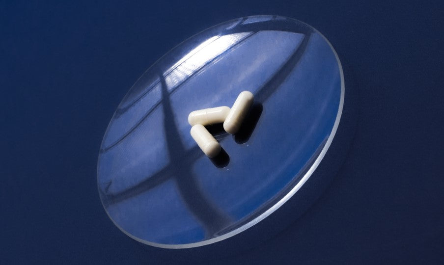 Fatty15's C15 supplement capsules on clear round dish.