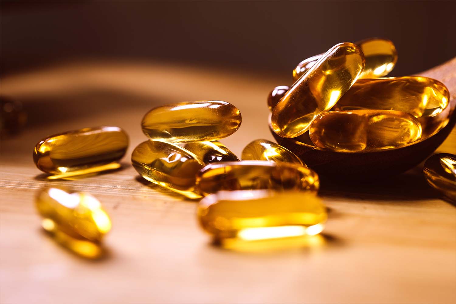 Golden supplement capsules on a wooden surface.