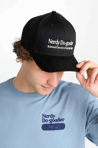 Man wearing a blue Nerdy Do-gooder T-shirt and black cap, looking down.