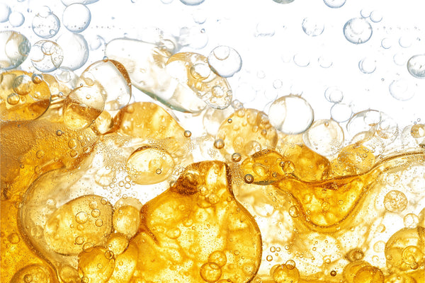 Golden oil bubbles rising in a vibrant liquid background.